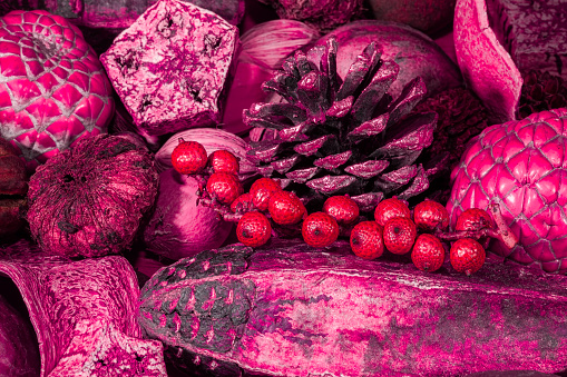 Red and pink toned Christmas potpourri decoration background image. Colorful xmas pot-pourri decorative backdrop. Close up of traditional pinecone and berries selection.