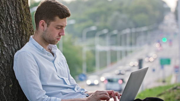istock A Young Man Using a Laptop Outdoors 887040962