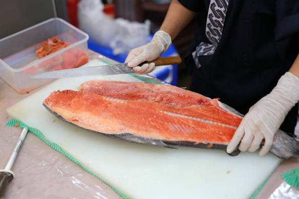 istock Close-up hands of chef cuts the salmon on the table. 887059038