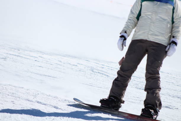 Snowboarder in slope Lower half view of snowboarder coming down the slope marie puddu stock pictures, royalty-free photos & images