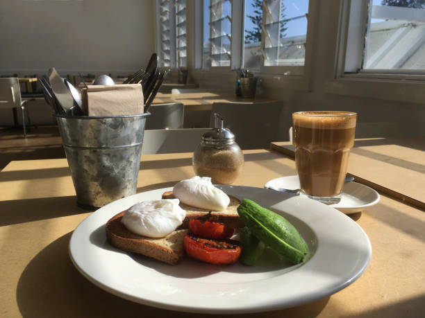 istock Breakfast time, poached eggs on toast with sliced avocado and char grilled tomato. 887061726