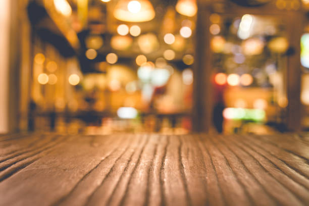 istock Wood table top with blur of lighting in night cafe 887069746