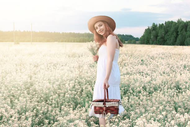 fille en robe blanche dans un champ de fleurs jaunes floraison - wedding suit photos et images de collection