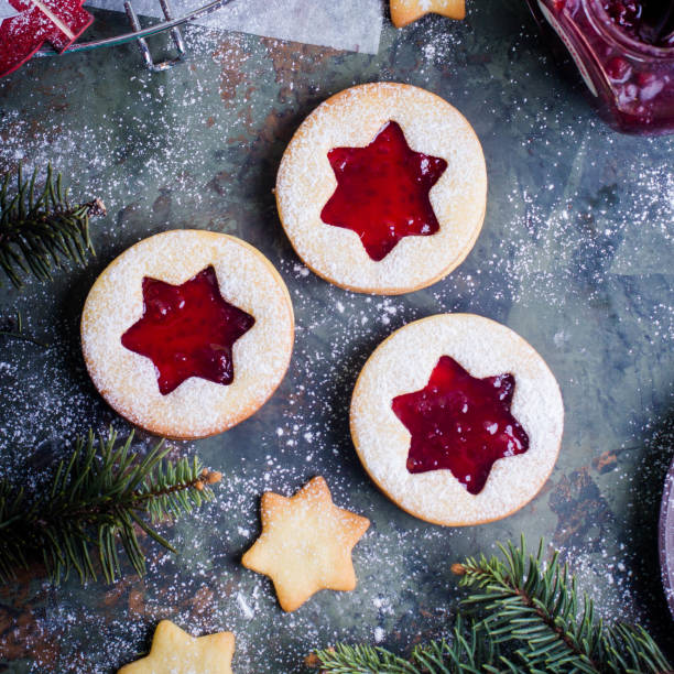 istock Christmas Linzer cookies with raspberry jam on green table background. Top view and copy space 887093696