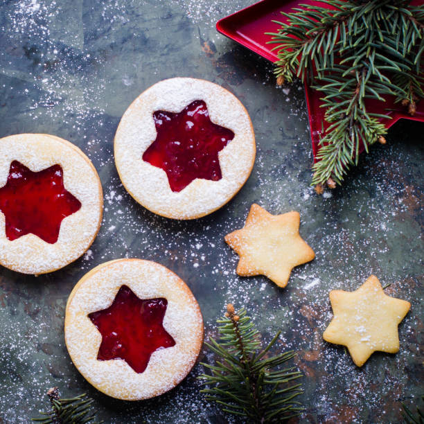 istock Christmas Linzer cookies with raspberry jam on green table background. Top view and copy space 887093700