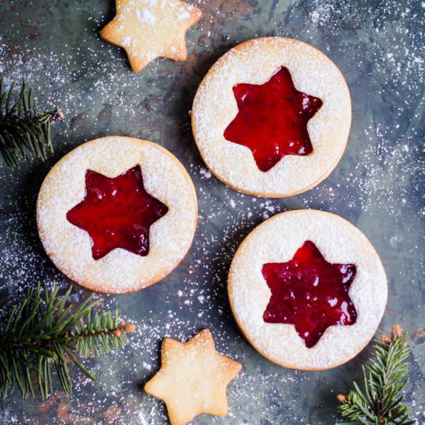 istock Christmas Linzer cookies with raspberry jam on green table background. Top view and copy space 887093706