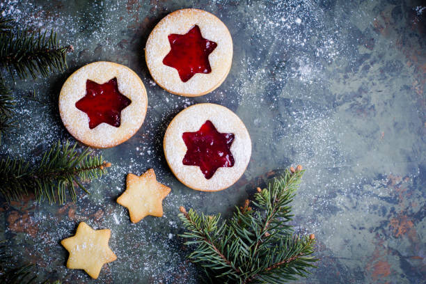 istock Christmas Linzer cookies with raspberry jam on green table background. Top view and copy space 887093712