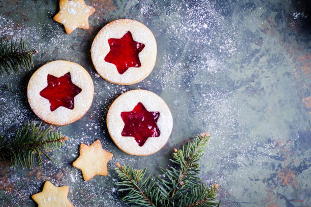istock Christmas Linzer cookies with raspberry jam on green table background. Top view and copy space 887093716
