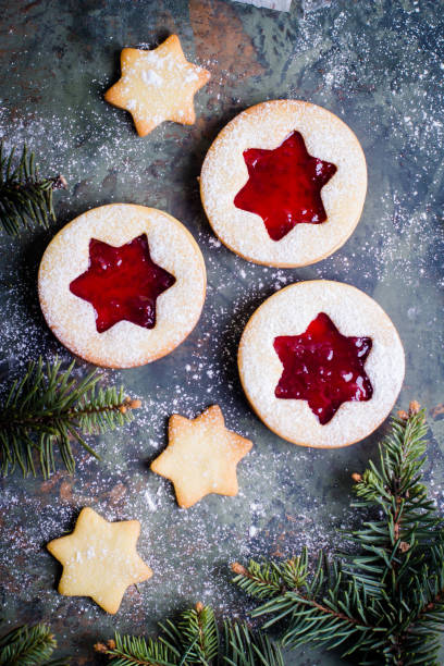 istock Christmas Linzer cookies with raspberry jam on green table background. Top view and copy space 887093720