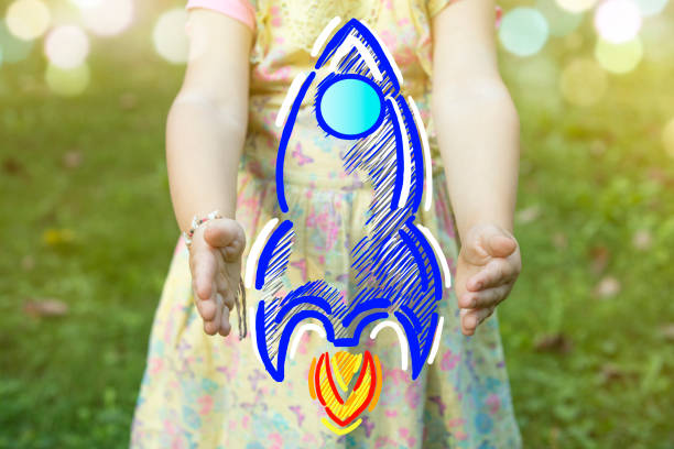 istock Child holding a rocket drawing as startup concept outdoors on a sunny day 887100646