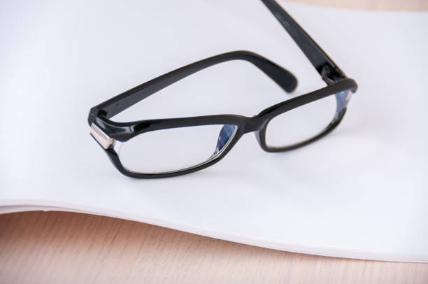 istock Black glasses on an open blank album 887103146