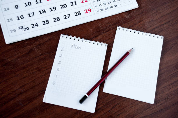 istock On the table lie a notebook, a pencil and a calendar 887106126