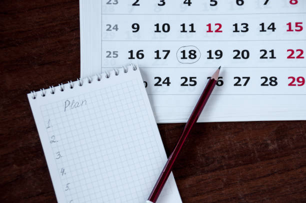 istock On the table lie a notebook, a pencil and a calendar 887106150
