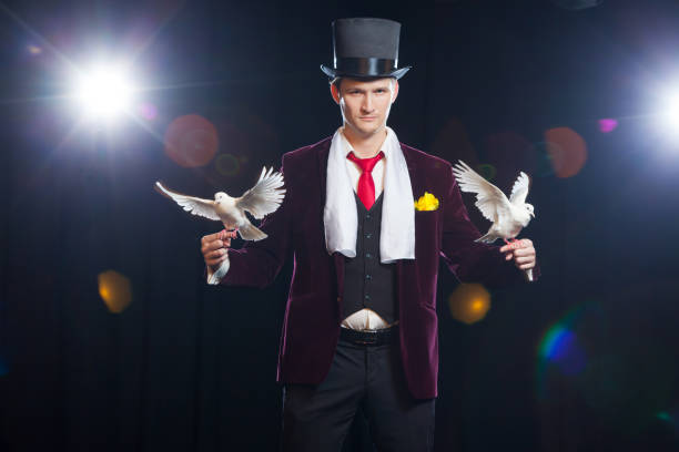 istock The magician with a two flying white Doves. on a black background 887126888