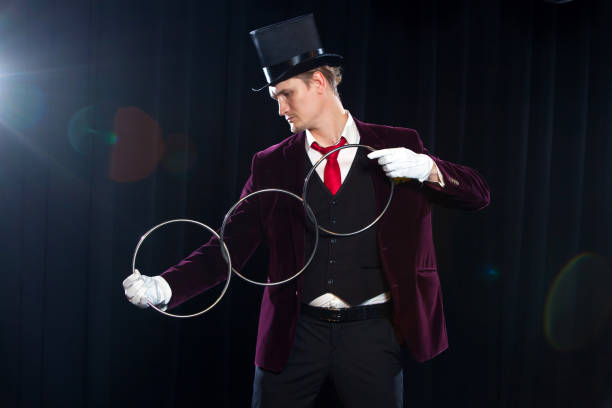 istock magic, performance, circus, show concept - magician in top hat showing trick with linking rings 887127228