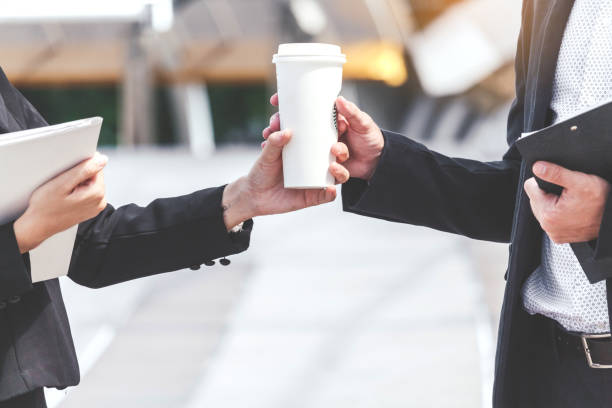 istock Business people holding a paper coffee cup 887127286