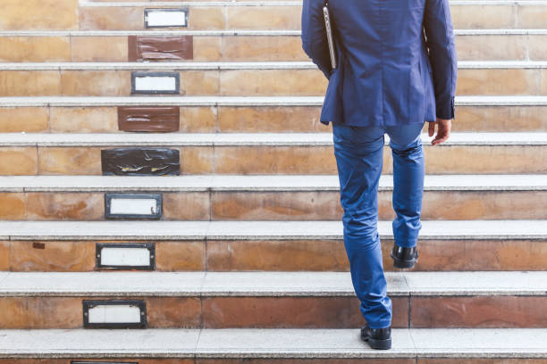 istock Businessman walking up the stairs 887127328