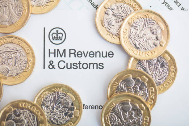 UK Inland Revenue Tax Form An editorial stock photo of the UK Inland Revenue Tax forms with the new 2017 One Pound Coins. one pound coin photos stock pictures, royalty-free photos & images