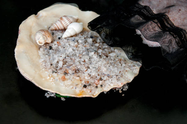 istock Sea salt and shallow seashells on a black background 887133628