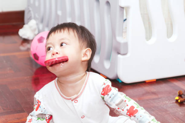Baby boy biting a toy stock photo