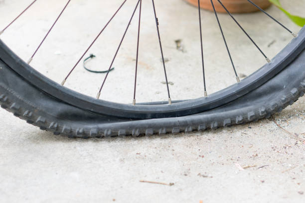 istock Bicycle wheel with flat tyre on the concrete road. 887148198