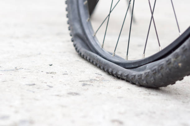 istock Bicycle wheel with flat tyre on the concrete road. 887148210