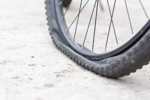 istock Bicycle wheel with flat tyre on the concrete road. 887148232