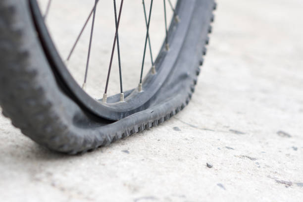 istock Bicycle wheel with flat tyre on the concrete road. 887148268