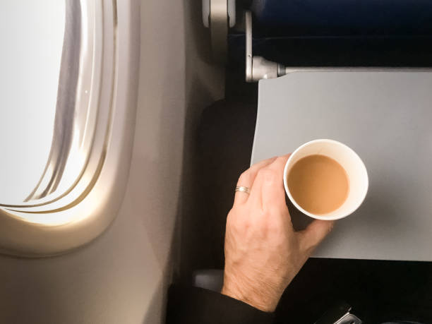 Pasajero hombre sosteniendo una taza de café en el avión - foto de stock