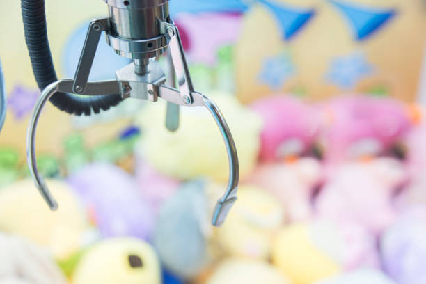 istock Claw Game or cabinet catches the doll.A mechanical arm selecting a random soft toy in a vending machine 887166952