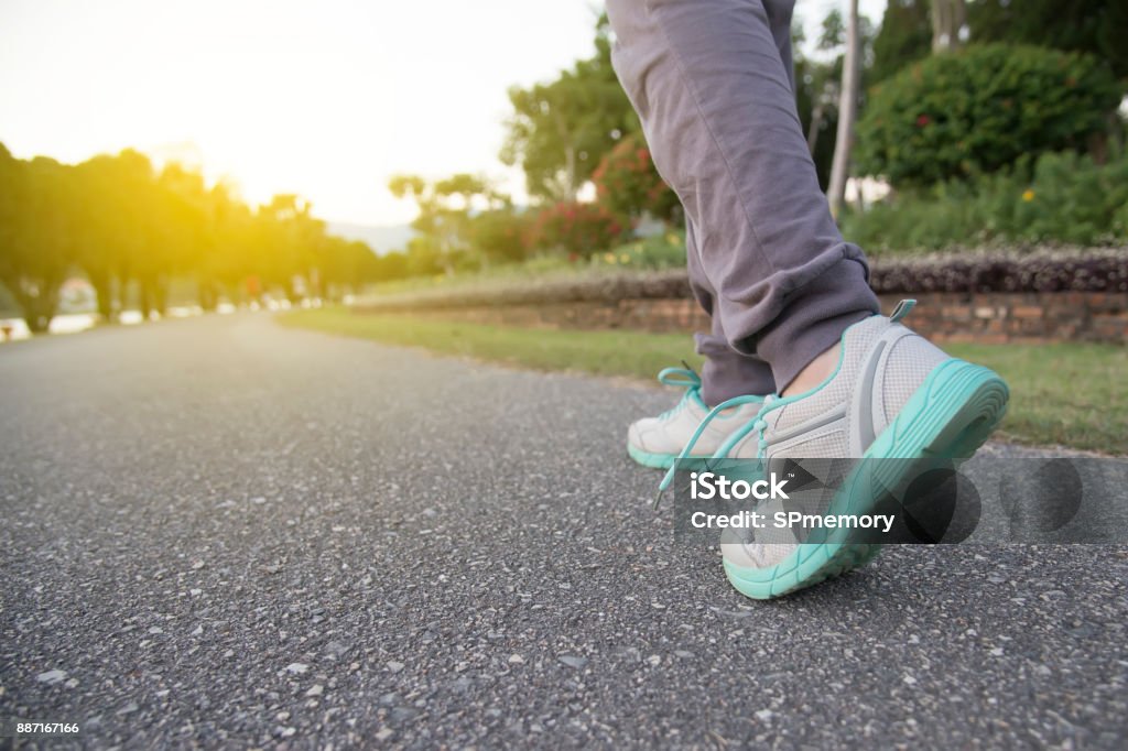 Road to success,running on road with sports shoes,healthy lifestyle sports woman running, female legs with sneakers jogging in evening prepare for marathon Racewalking Stock Photo