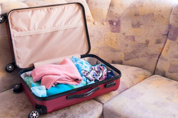 istock Charges for the journey, an open suitcase with women's things on the couch 887171818