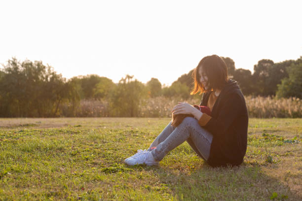 istock woman sitting on lawn playing with poodle 887183418