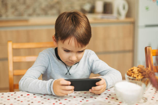 istock Little boy holding a phone in his hands 887200206