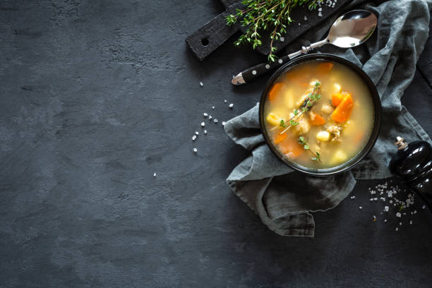 fresh fish soup in bowl on dark background, top view - caldo imagens e fotografias de stock