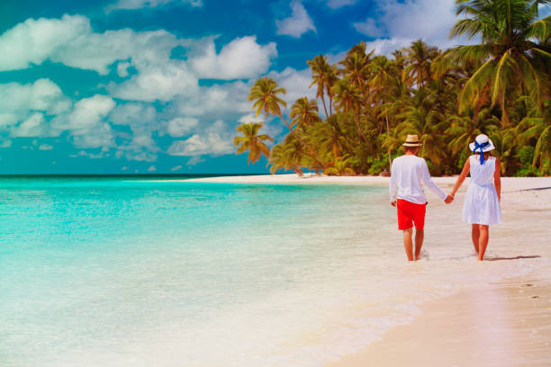 istock happy loving couple walk on beach 887208928