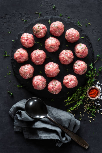 istock Raw meatballs on dark background, top view 887208952