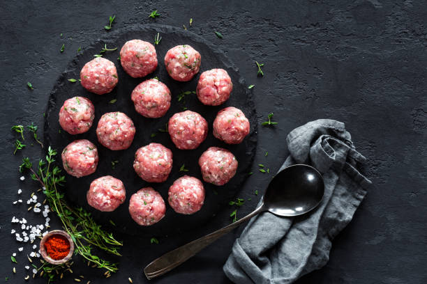 istock Raw meatballs on dark background, top view 887209062