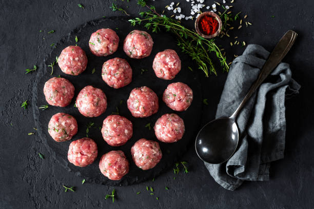 istock Raw meatballs on dark background, top view 887209064