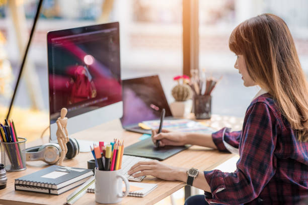 istock Young asian woman designer using desktop computer at her office 887217000