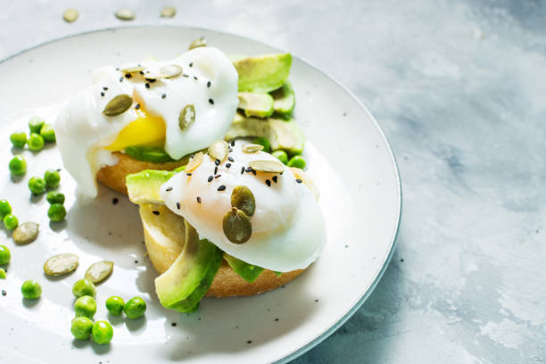 istock Delicious Poached Egg with Bread and Sliced Avocado on concrete background. 887223756