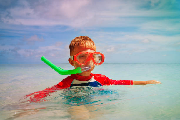 istock little boy swimming with mask at sea 887224546