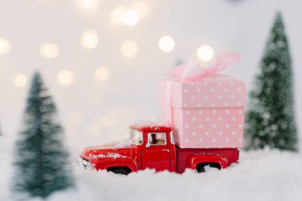 istock Red toy car carrying Christmas gift. 887225094