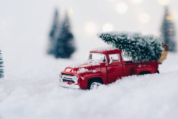istock Red toy car carrying Christmas tree. 887227144