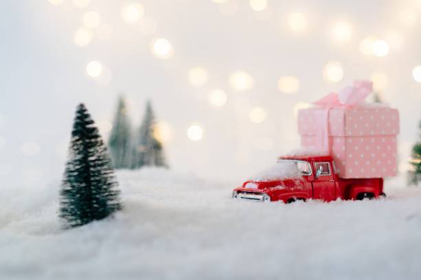istock Red toy car carrying Christmas gift. 887227168