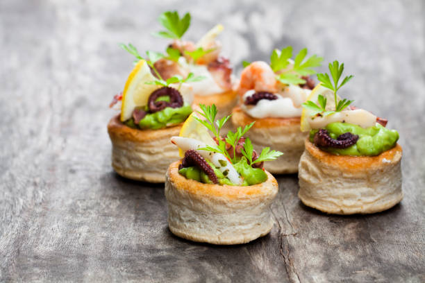 Vol-au-vents  puff pastry cases filled with salted squid and octopus Vol-au-vents  puff pastry cases filled with salted squid and octopus canape stock pictures, royalty-free photos & images