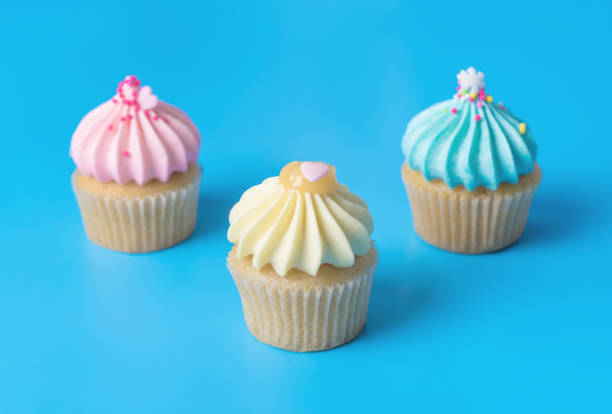 istock Three pastel colorful Mini cupcake muffin on blue background 887239426