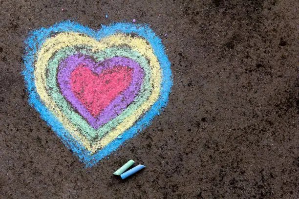 Photo of chalk drawing: colorful hearts on asphalt