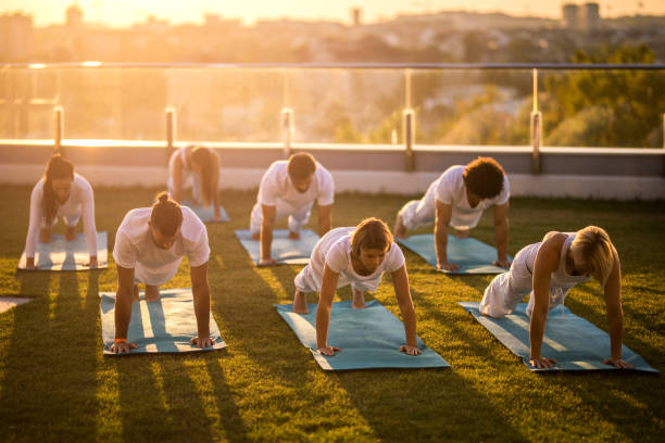 istock Large group of athletes in a plank position on a penthouse balcony. 887242992