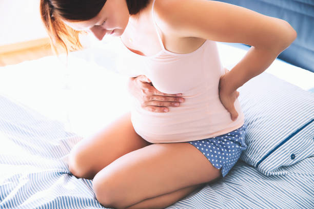 femme enceinte souffrant de douleurs lombaires. - abdomen women massaging human hand photos et images de collection